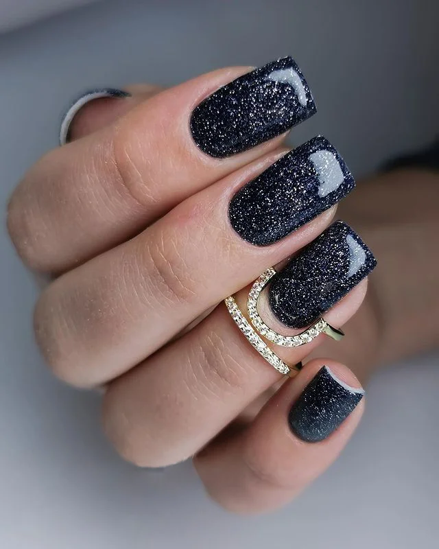 Black nails adorned with multi-colored glitter accents