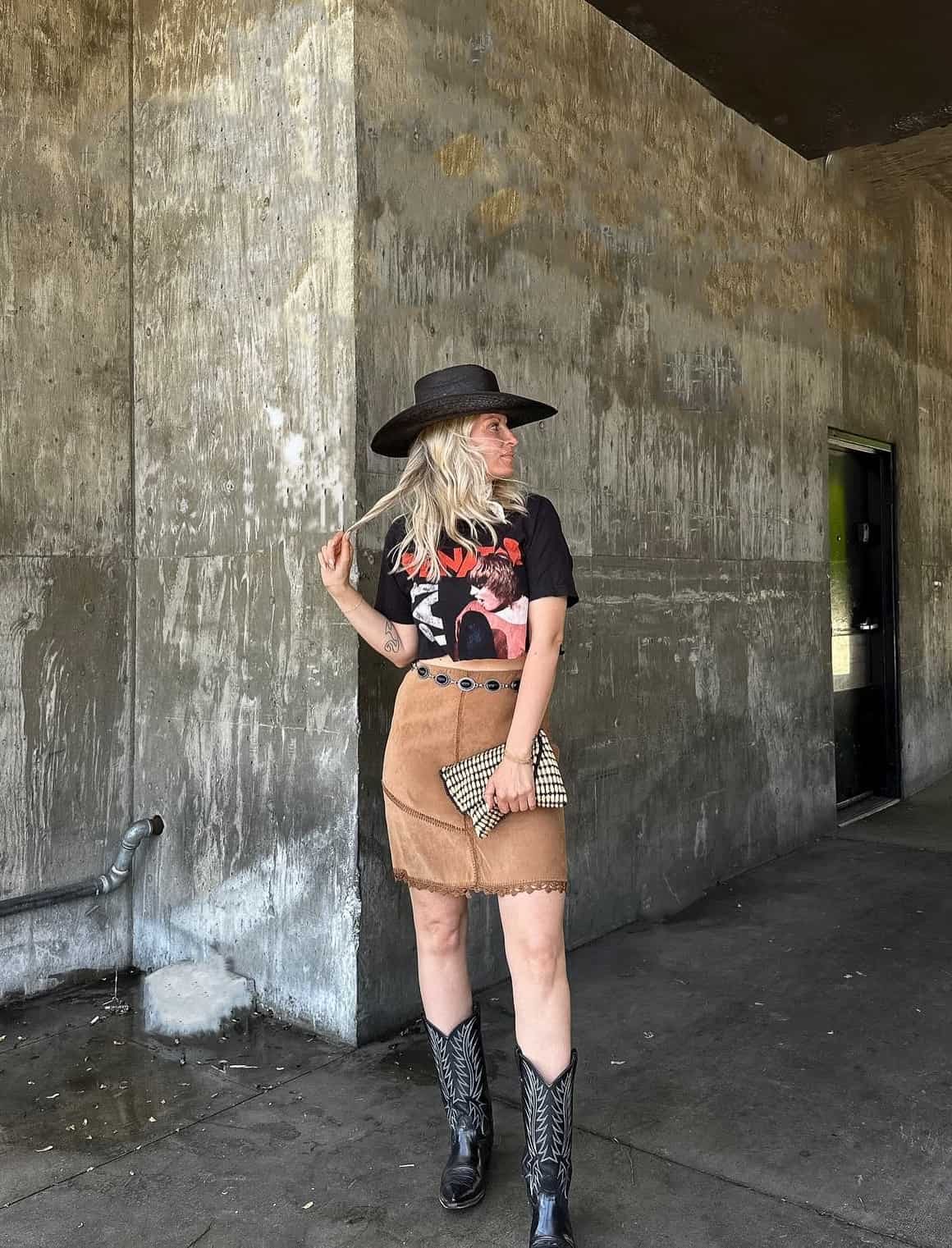 Woman in flared denim jeans, a fitted top, and a wide-brimmed cowboy hat