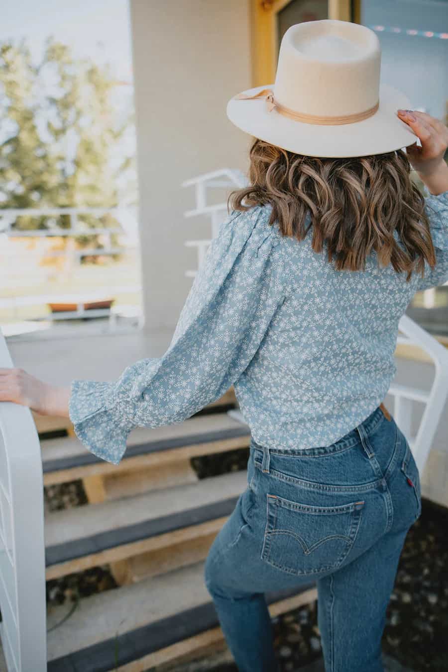 Woman in a prairie-inspired white top, long skirt, and cowboy boots