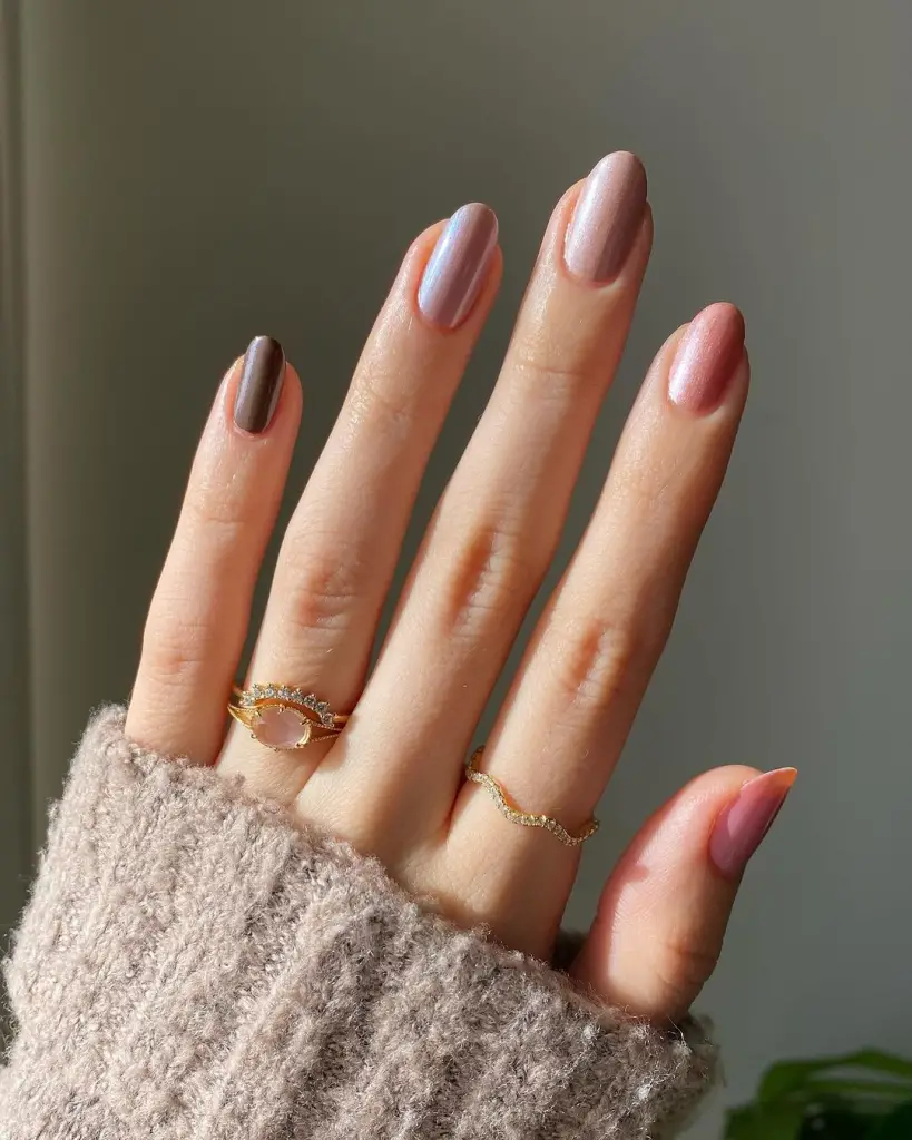 Neutral-toned nails with gold embellishments and geometric accents