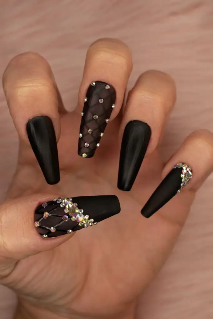 Matte black nails enhanced with silver embellishments