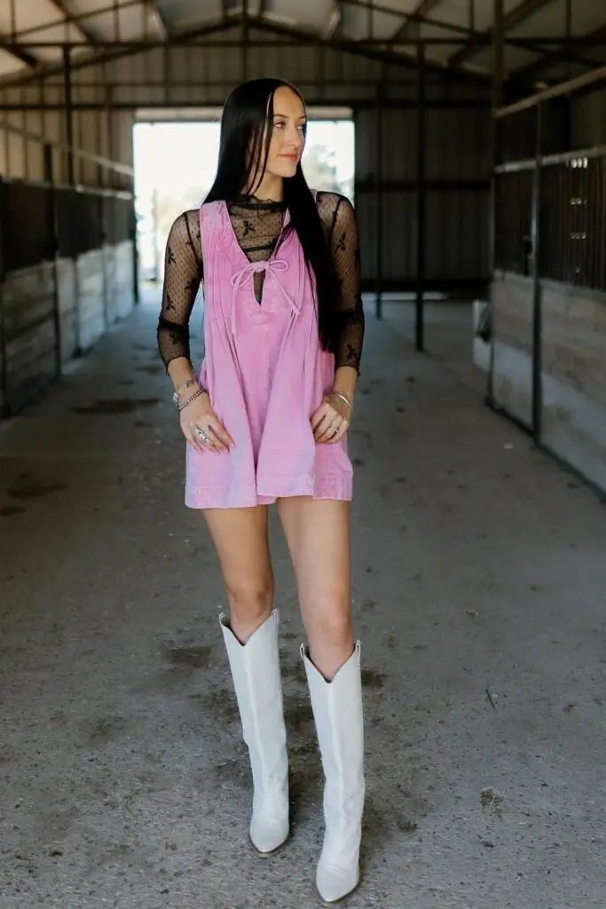 Woman in a long duster coat with jeans and cowboy boots