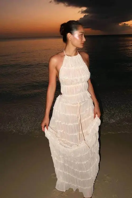 Woman in a White Lace Top Paired with a Flowing Pink Skirt